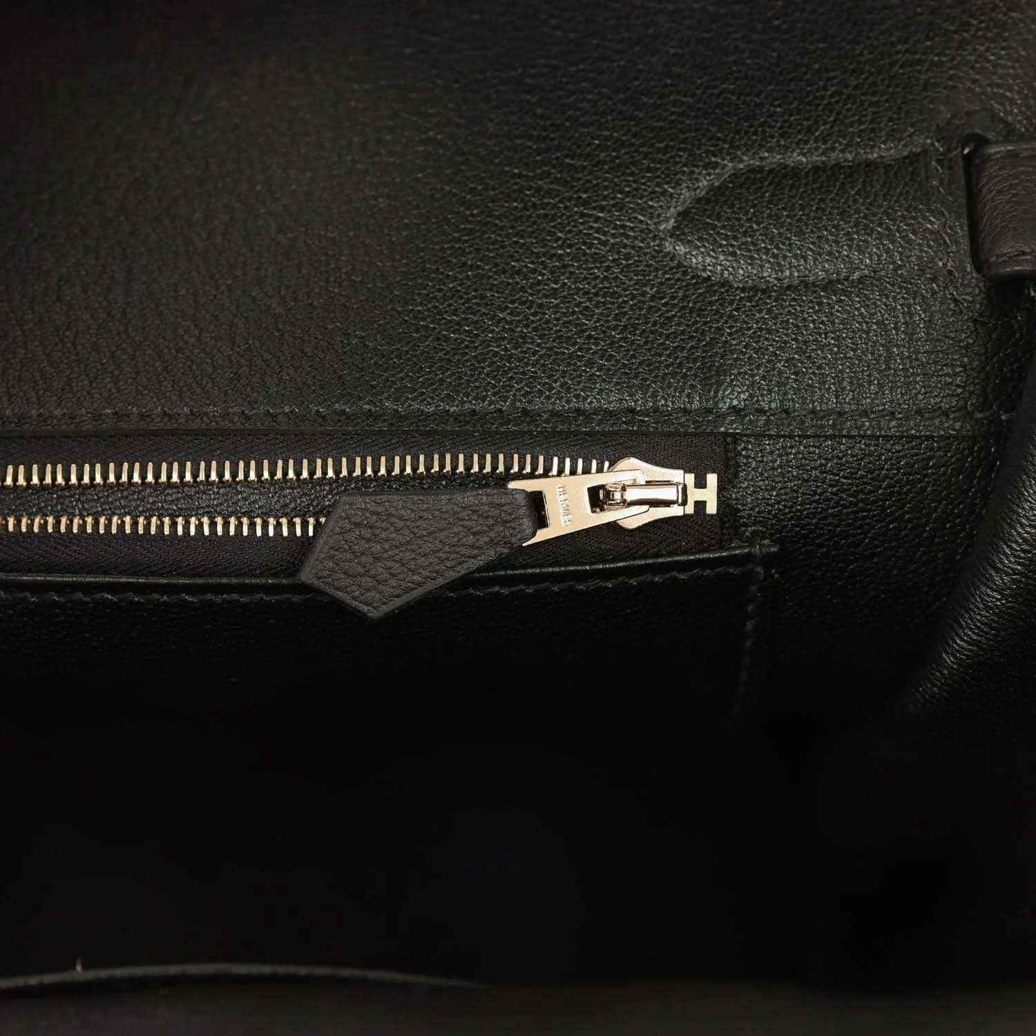 Black leather handbag interior zipper with gold-toned pull and hardware
