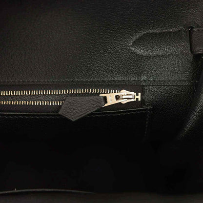 Black leather handbag interior zipper with gold-toned pull and hardware