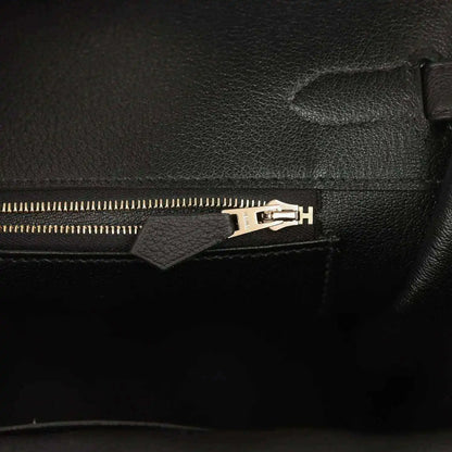 Black leather handbag interior zipper with gold-toned pull and hardware