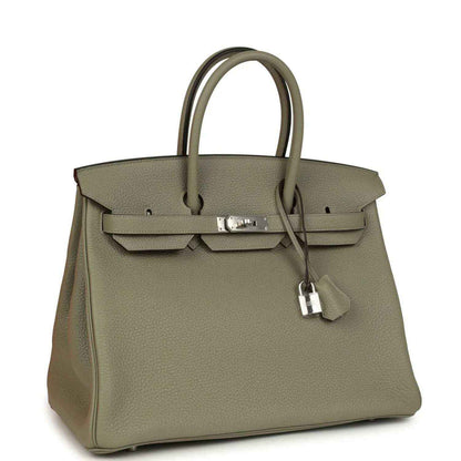 Sauge leather top-handle handbag with front flap, clasp, and hanging lock charm