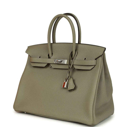 Sauge leather top-handle handbag with front flap, lock hardware, and key charm