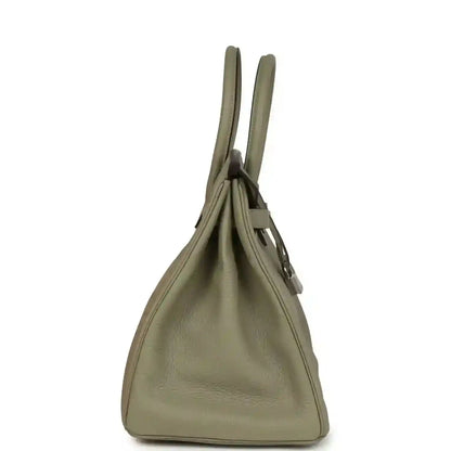 Sauge leather handbag with top handles and side view of the hinged flap