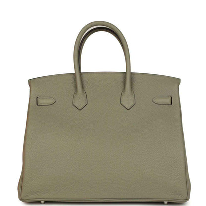Sauge leather handbag with top handles, back straps, and protective feet