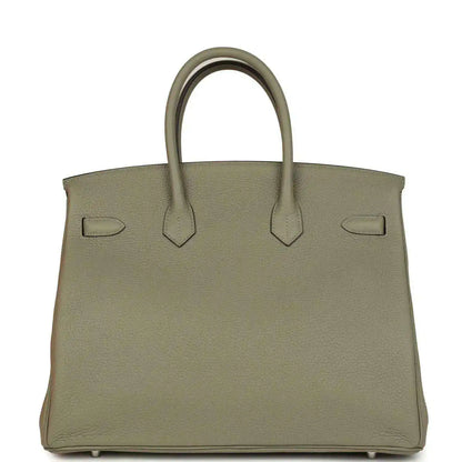 Sauge leather handbag with top handles, back straps, and protective feet