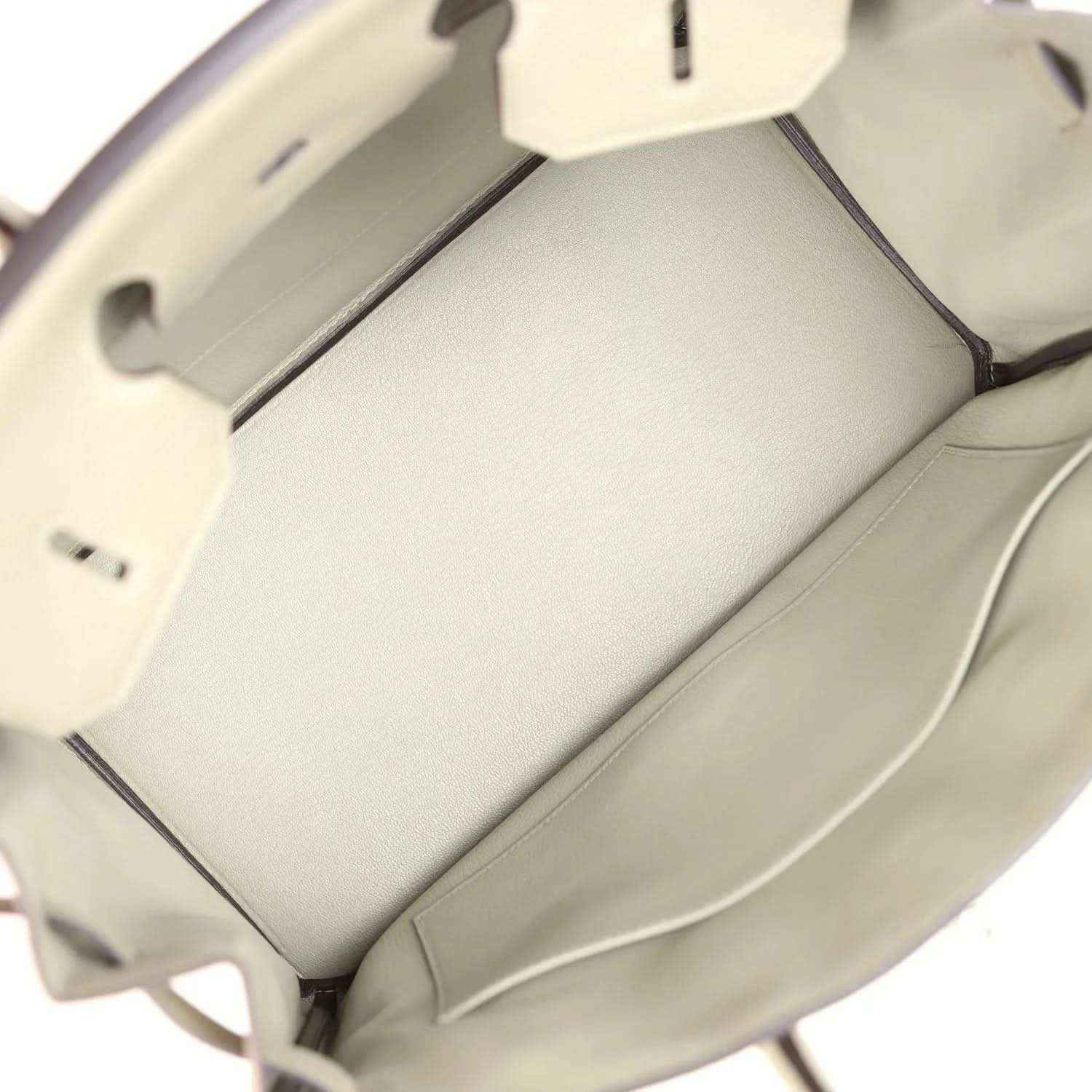 Open sauge leather handbag interior with smooth lining and front pocket