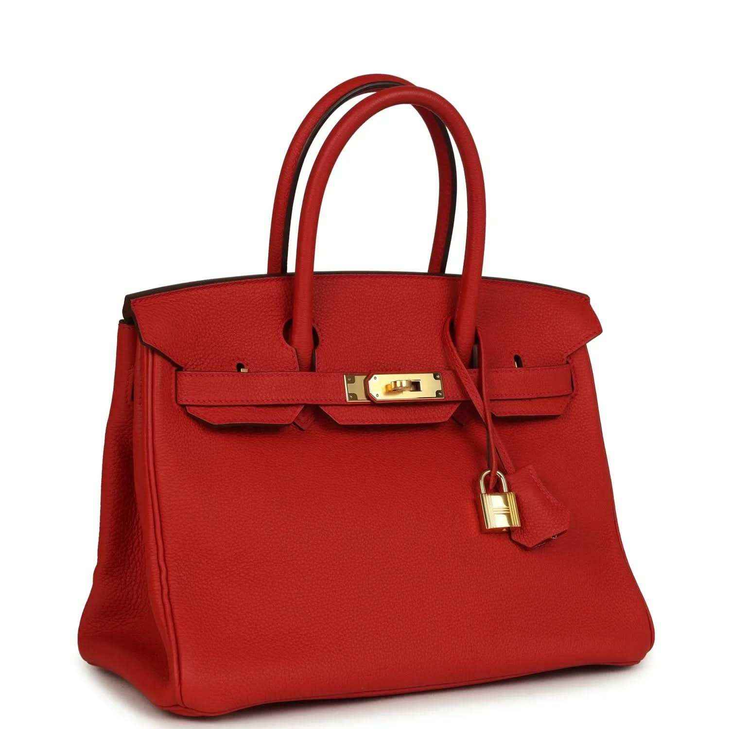 Red leather handbag with gold clasp hardware, lock detail, and top handles