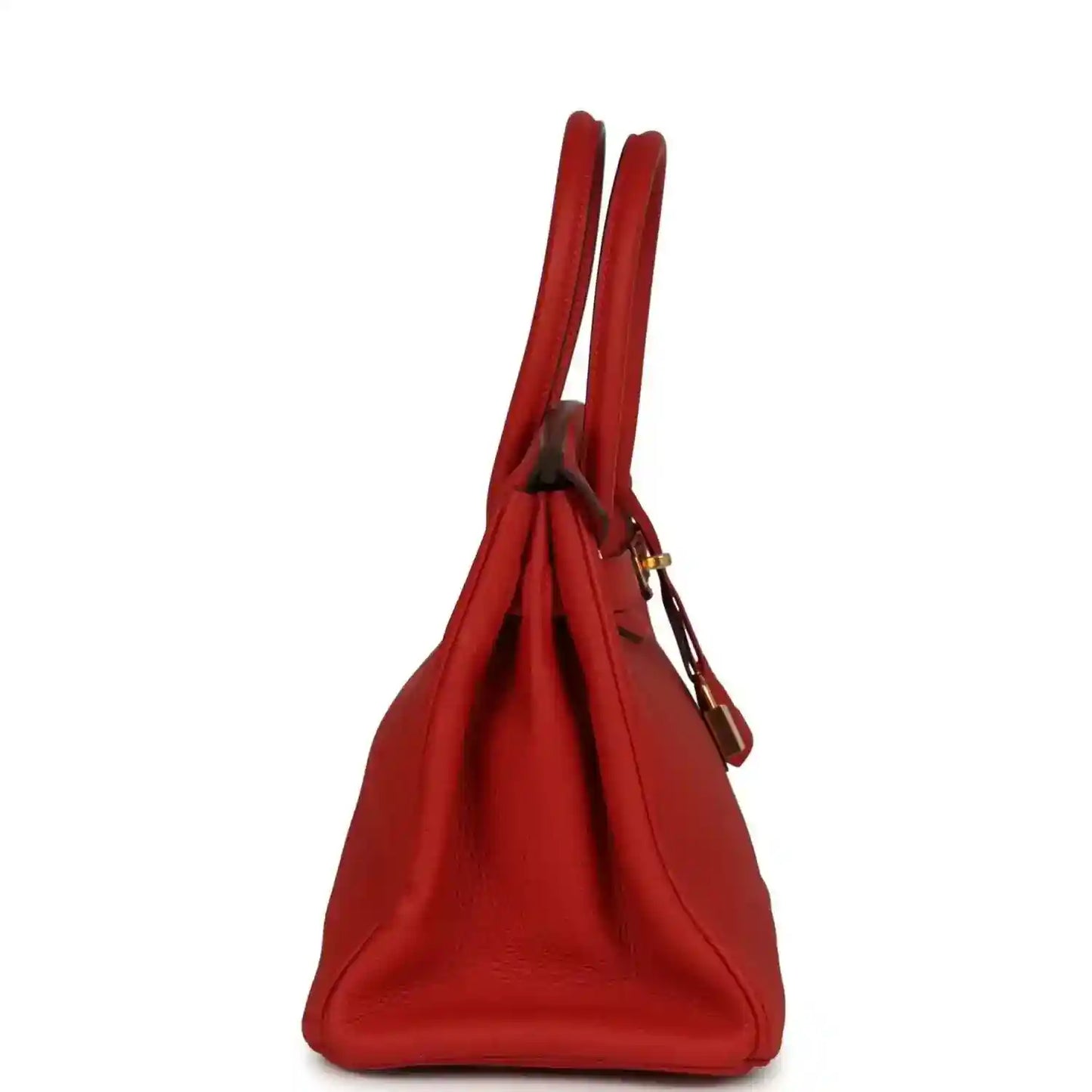 Red leather handbag side view with twin top handles and strap accents