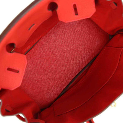Red leather handbag interior with structured compartments and zipper trim