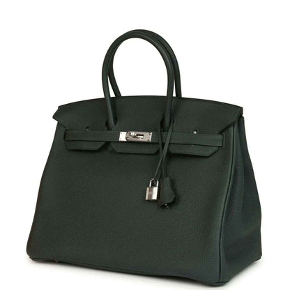Dark green Togo leather handbag with top handles and silver-tone front lock, angled view