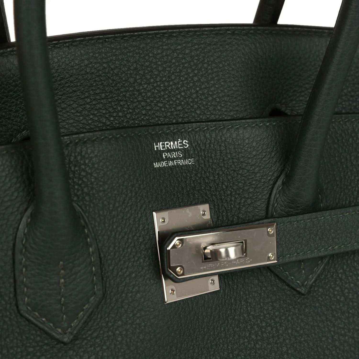 Dark green Togo leather handbag interior side with Hermes-style stamp and silver-tone front clasp
