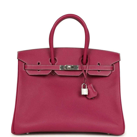 Pink Epsom leather handbag with top handles, front belt clasp, and hanging padlock charm.