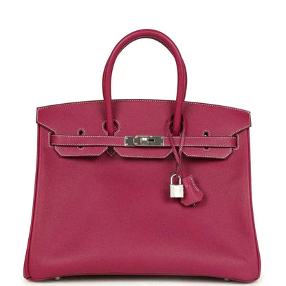 Pink Epsom leather handbag with top handles, front belt clasp, and hanging padlock charm.