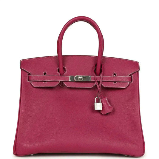 Pink Epsom leather handbag with top handles, front belt clasp, and hanging padlock charm.