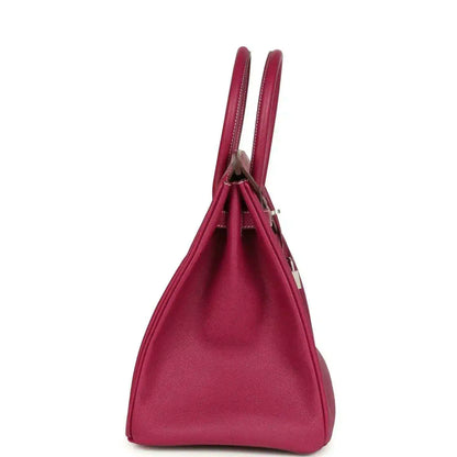Pink Epsom leather handbag with two rolled top handles, shown in side profile.
