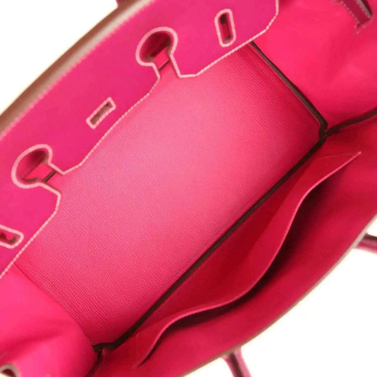 Pink leather interior with contrast stitching and a metal zipper pull detail.