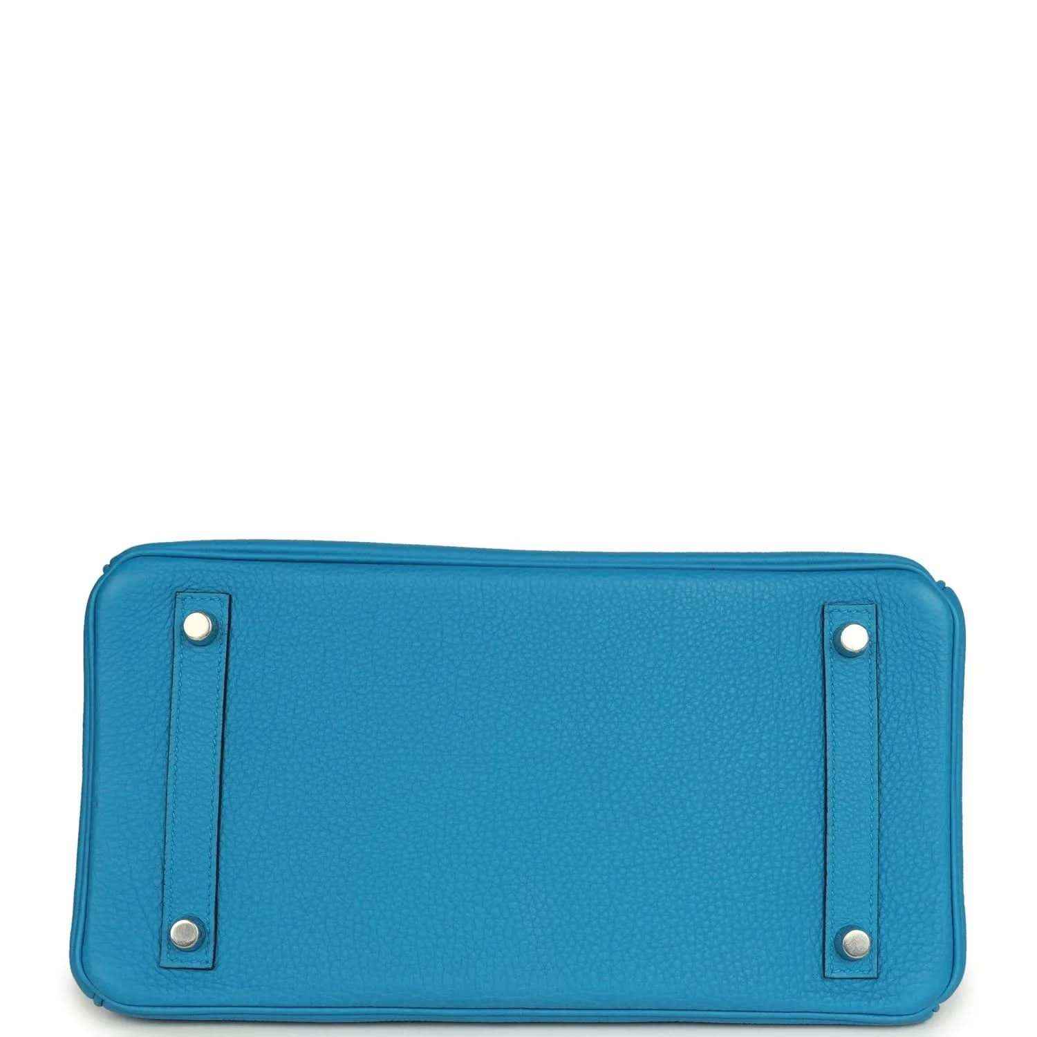 Blue leather back panel of handbag with two metal corner studs and stitching
