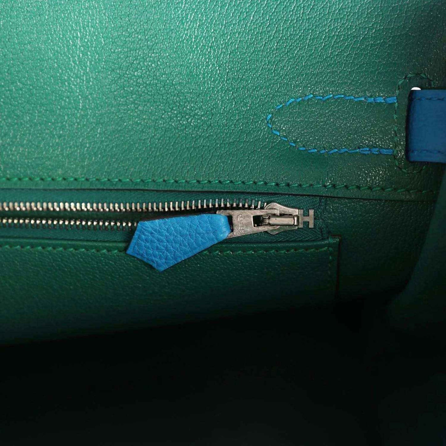Handbag interior zipper with metal pull and blue leather zipper tab