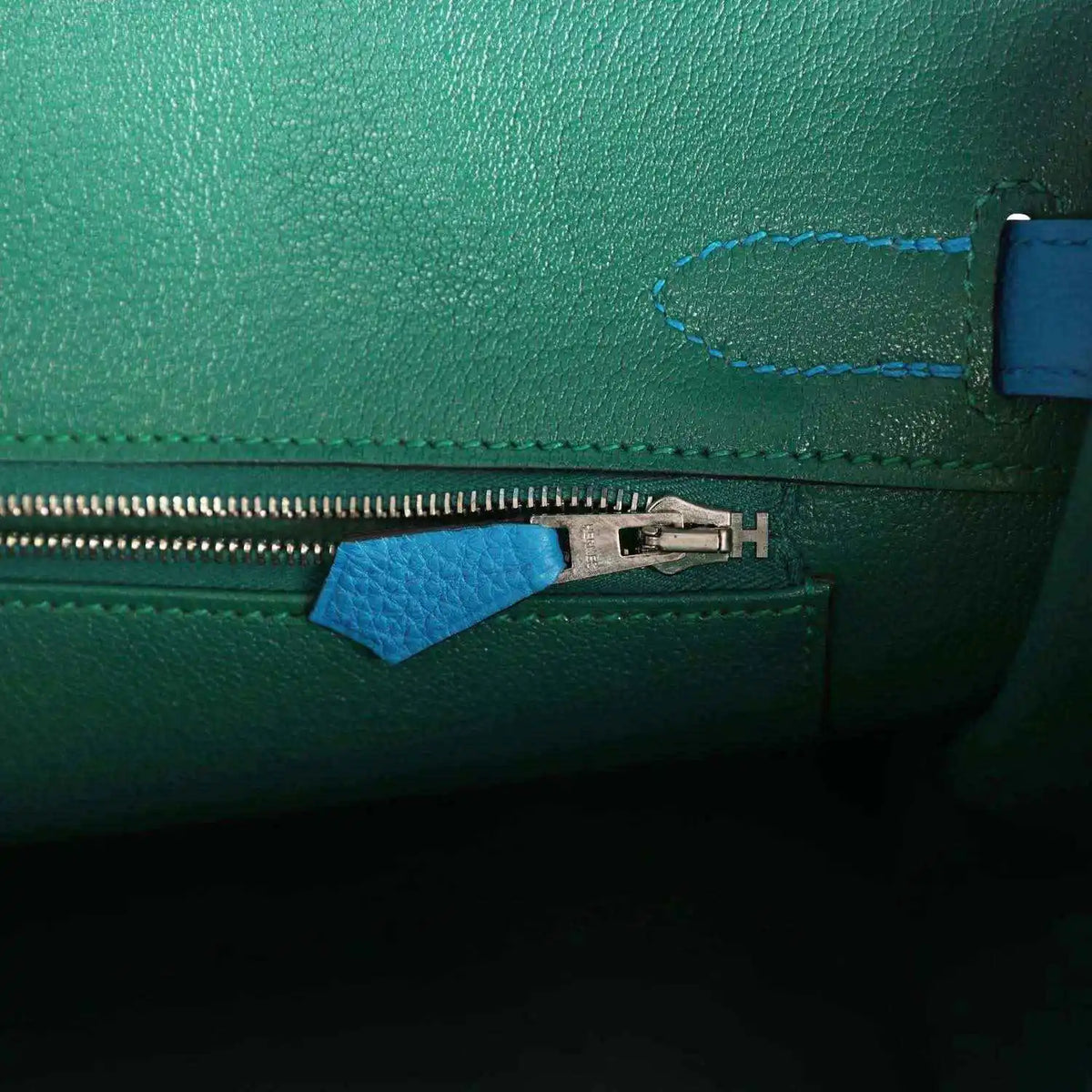 Handbag interior zipper with metal pull and blue leather zipper tab