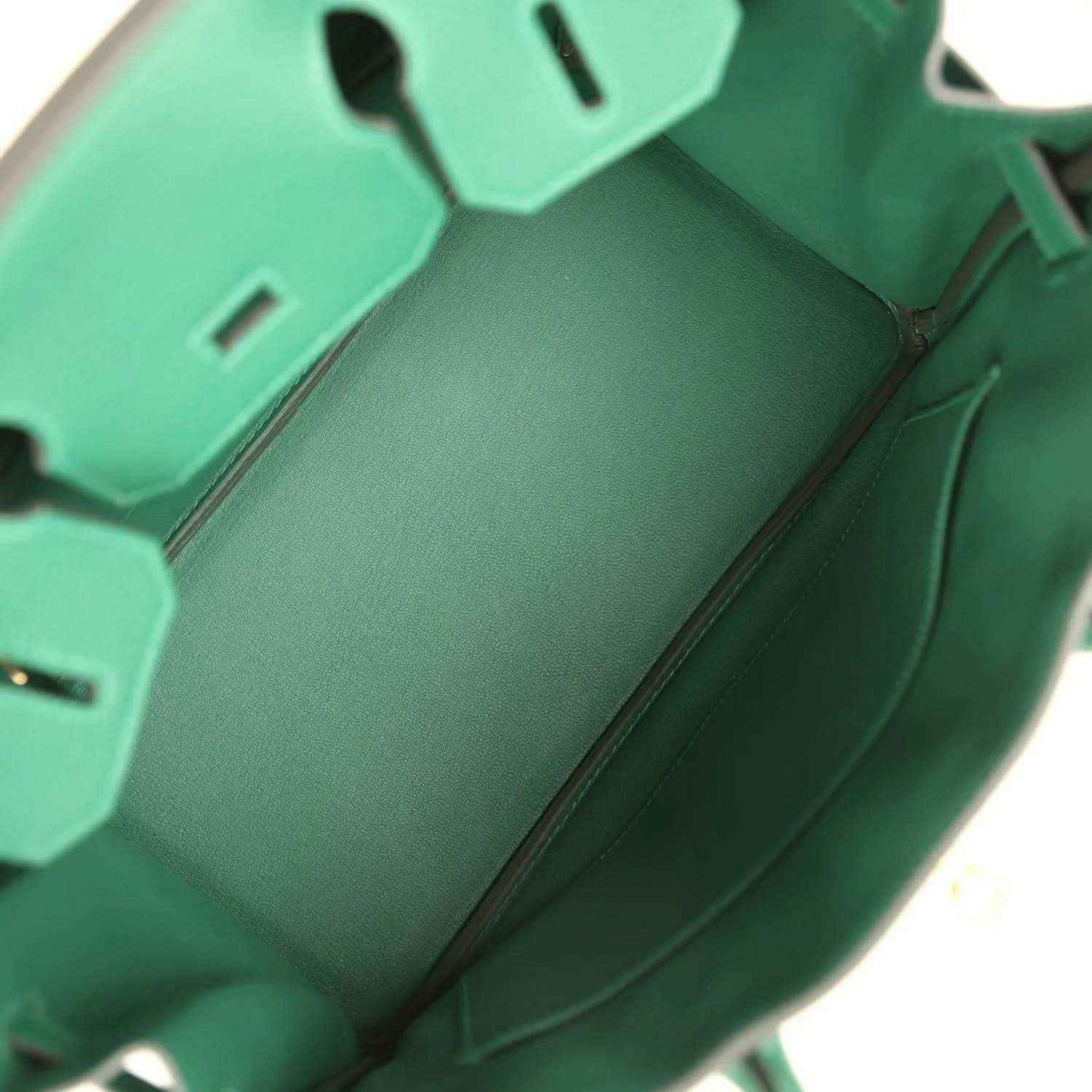 Green leather handbag interior with side pockets and zipper opening