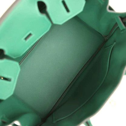 Green leather handbag interior with side pockets and zipper opening