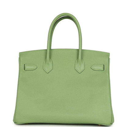Green leather handbag with top handles and stitched panel detailing
