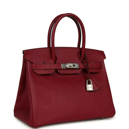 Red leather handbag with two top handles, front flap and hanging padlock