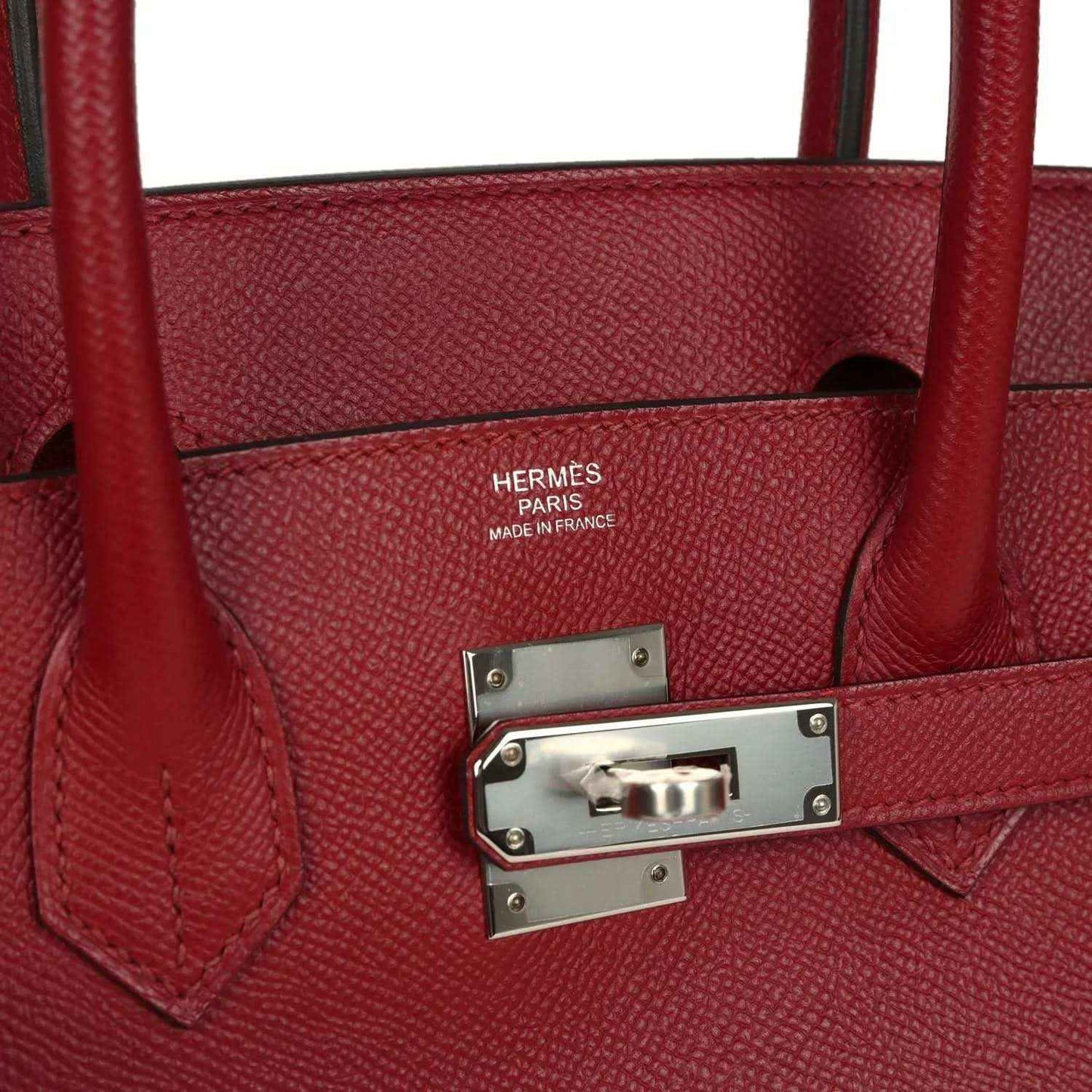 Red leather handbag with Hermes Paris branding plaque and metal strap hardware