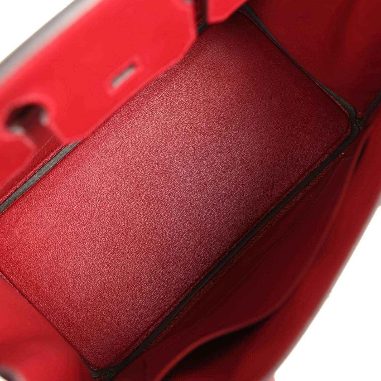 Red leather interior pocket panel with seam stitching and black trim edge