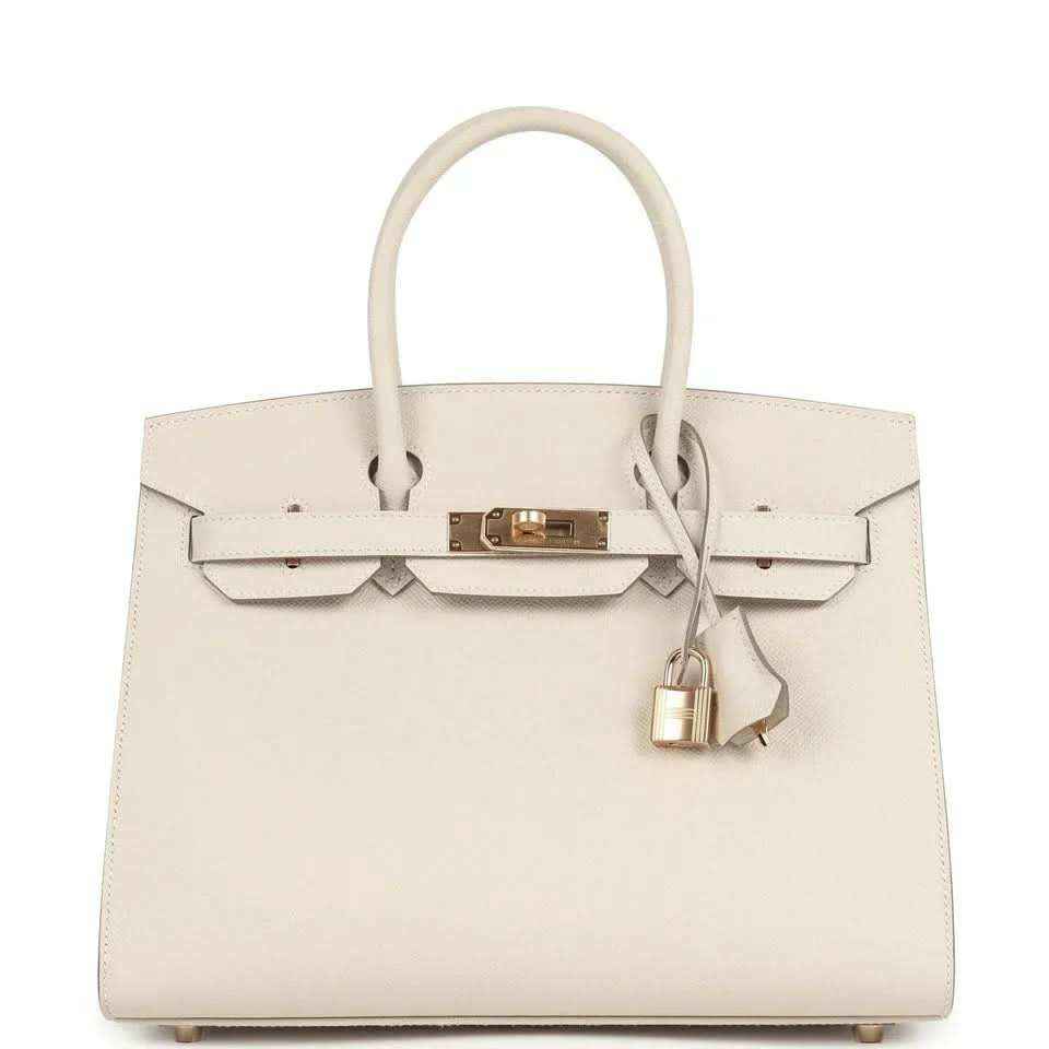 Light cream leather handbag with gold front lock and top handles