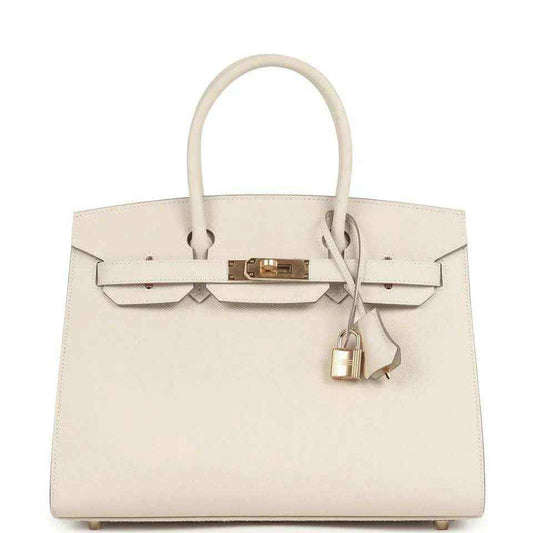 Light cream leather handbag with gold front lock and top handles