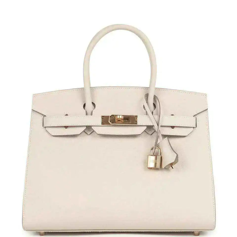 Light cream leather handbag with gold front lock and top handles