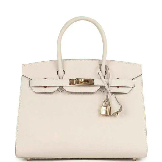 Light cream leather handbag with gold front lock and top handles