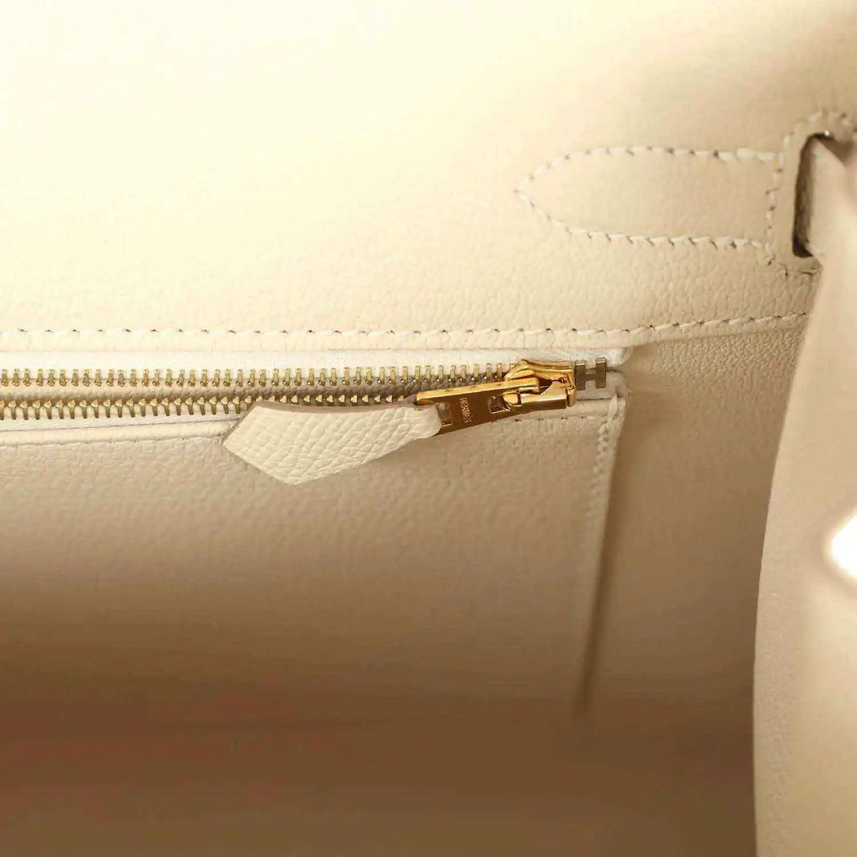 Light cream leather handbag with gold zipper and inner pocket opening