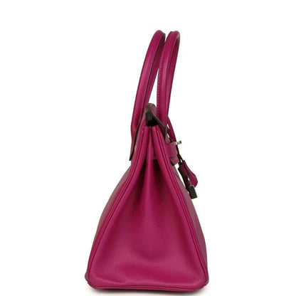 Rose-purple pebbled leather handbag side view with top handles and slim strap loop