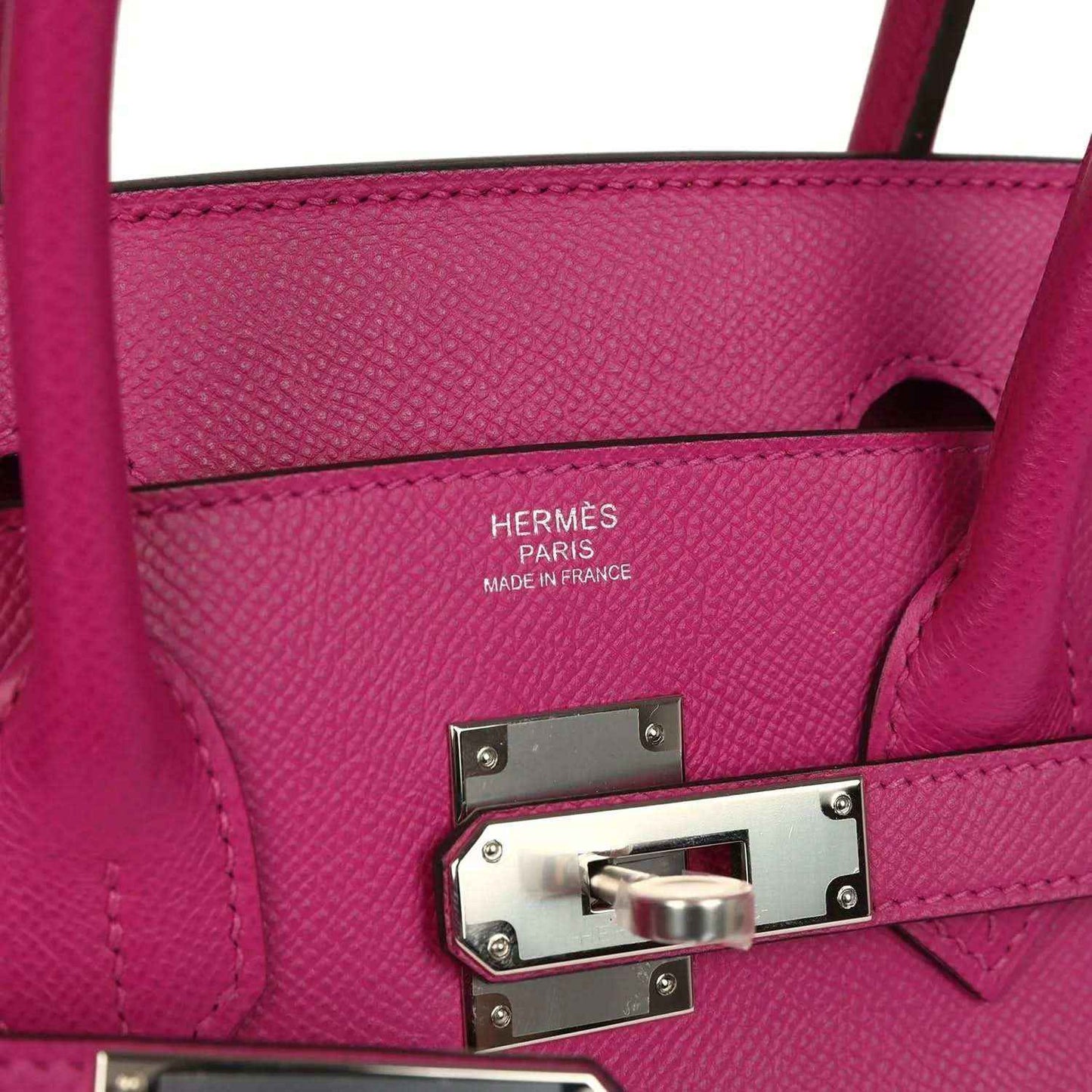 Rose-purple leather stamp area with HERMÈS text and silver lock hardware plate
