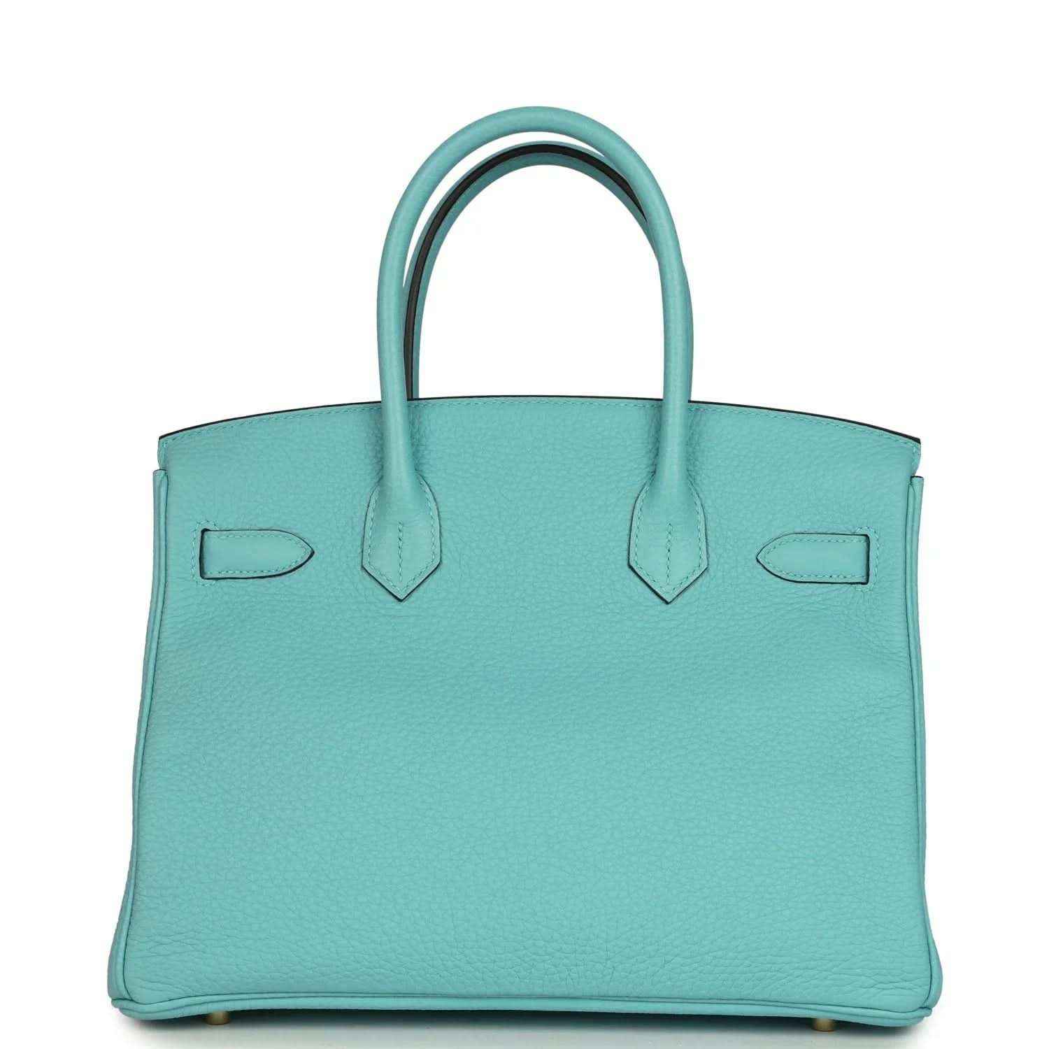 Teal leather handbag with structured sides, top handles, and gold-tone base feet