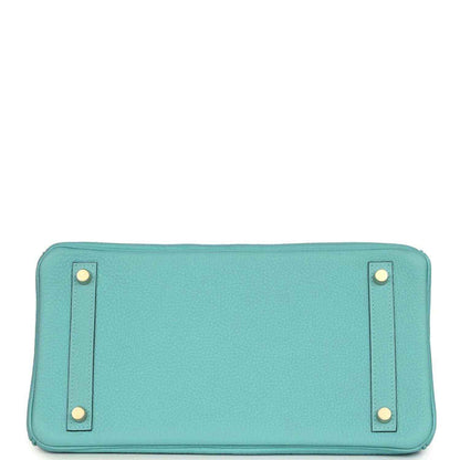 Teal leather handbag base with four corner feet, stitched edges, and snap-tab hardware