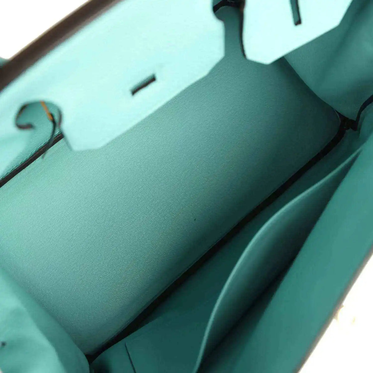 Teal leather handbag interior view with front wall seam lines and structured inner base