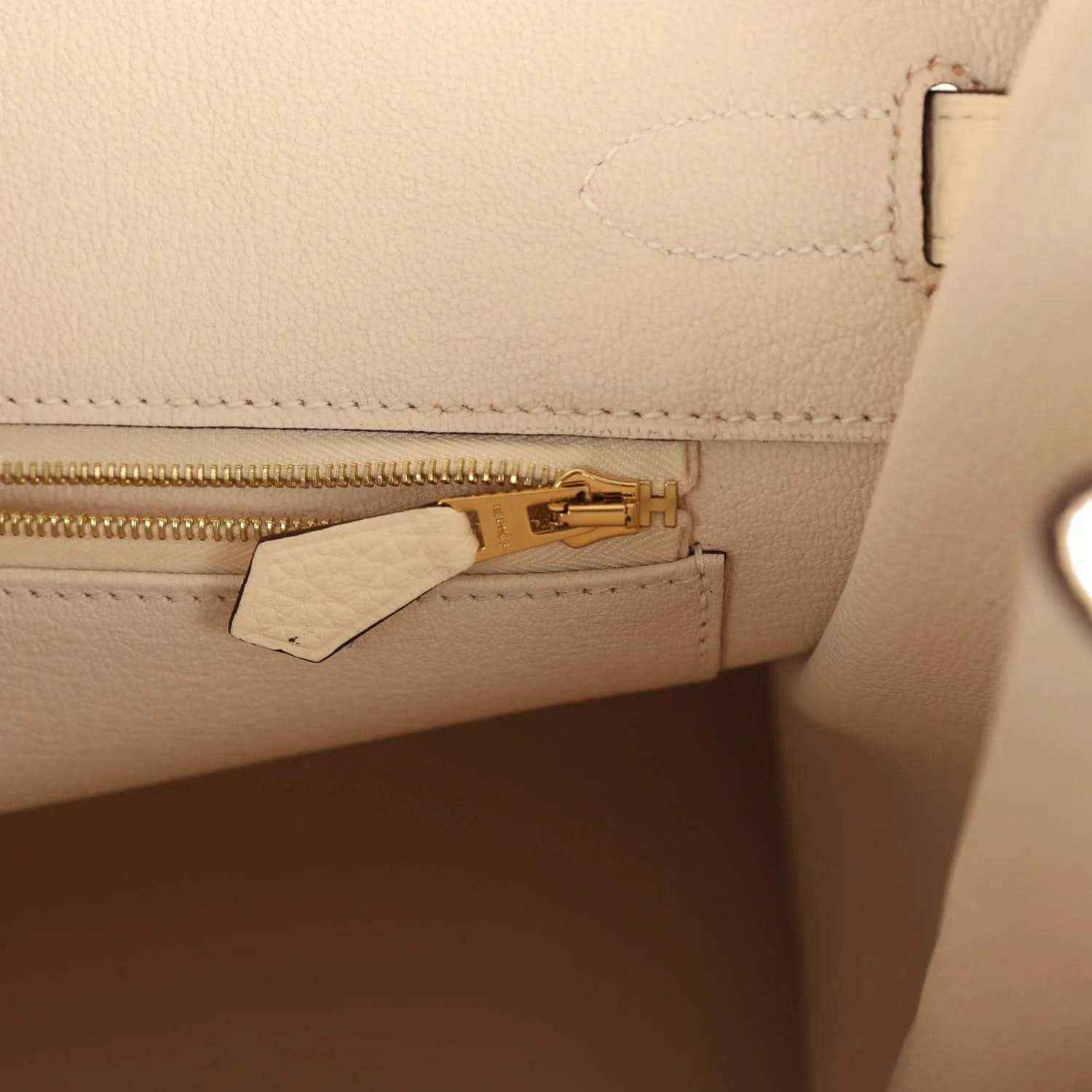 Cream leather interior pocket with gold zipper pull and leather tab
