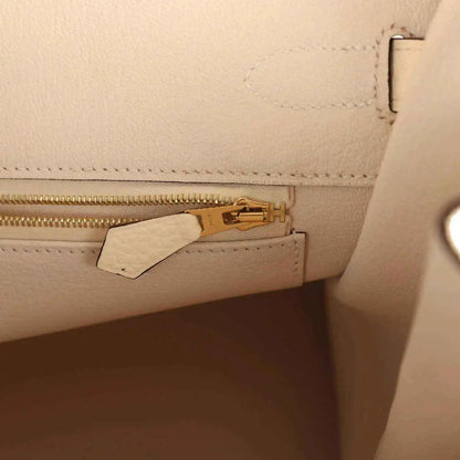Cream leather interior pocket with gold zipper pull and leather tab
