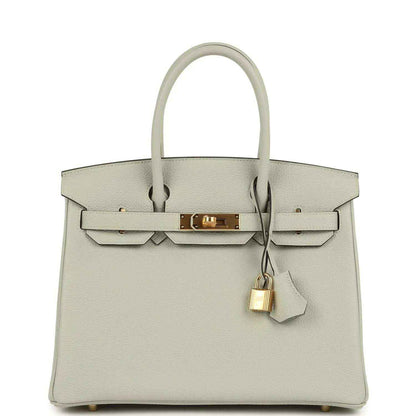 Light gray structured leather handbag with top handles, front flap, and gold lock clasp