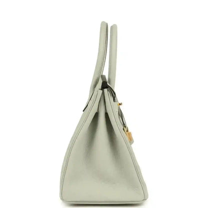 Light gray leather handbag with two top handles and gold-toned side hardware