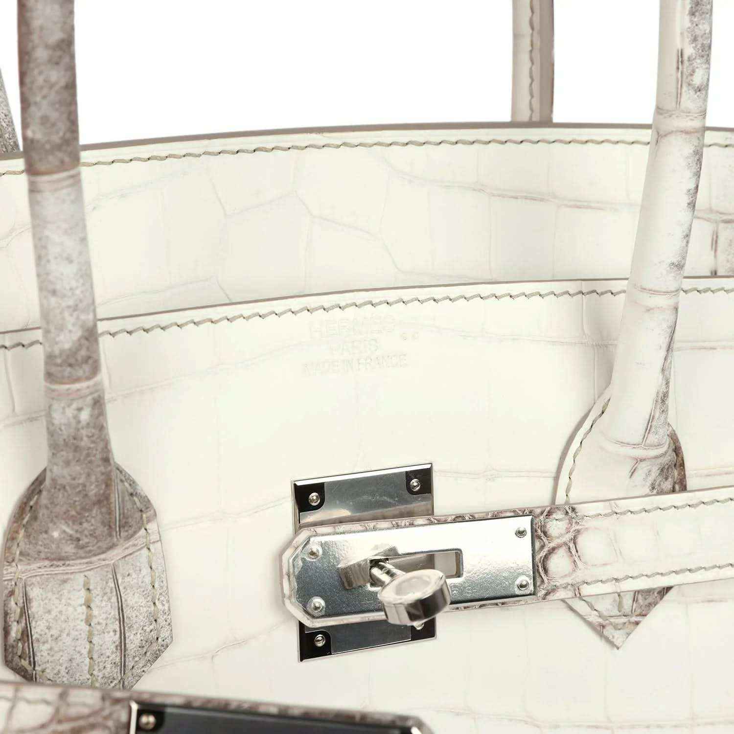 Ivory crocodile-textured handbag with metal latch lock and stitched strap tab