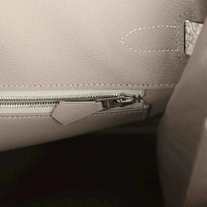 Ivory handbag interior with zipper compartment and stitched pocket edge