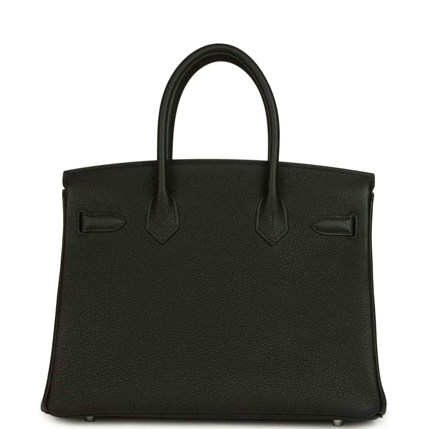 Black leather handbag front with top handles, stitched seams and flap pocket detailing.