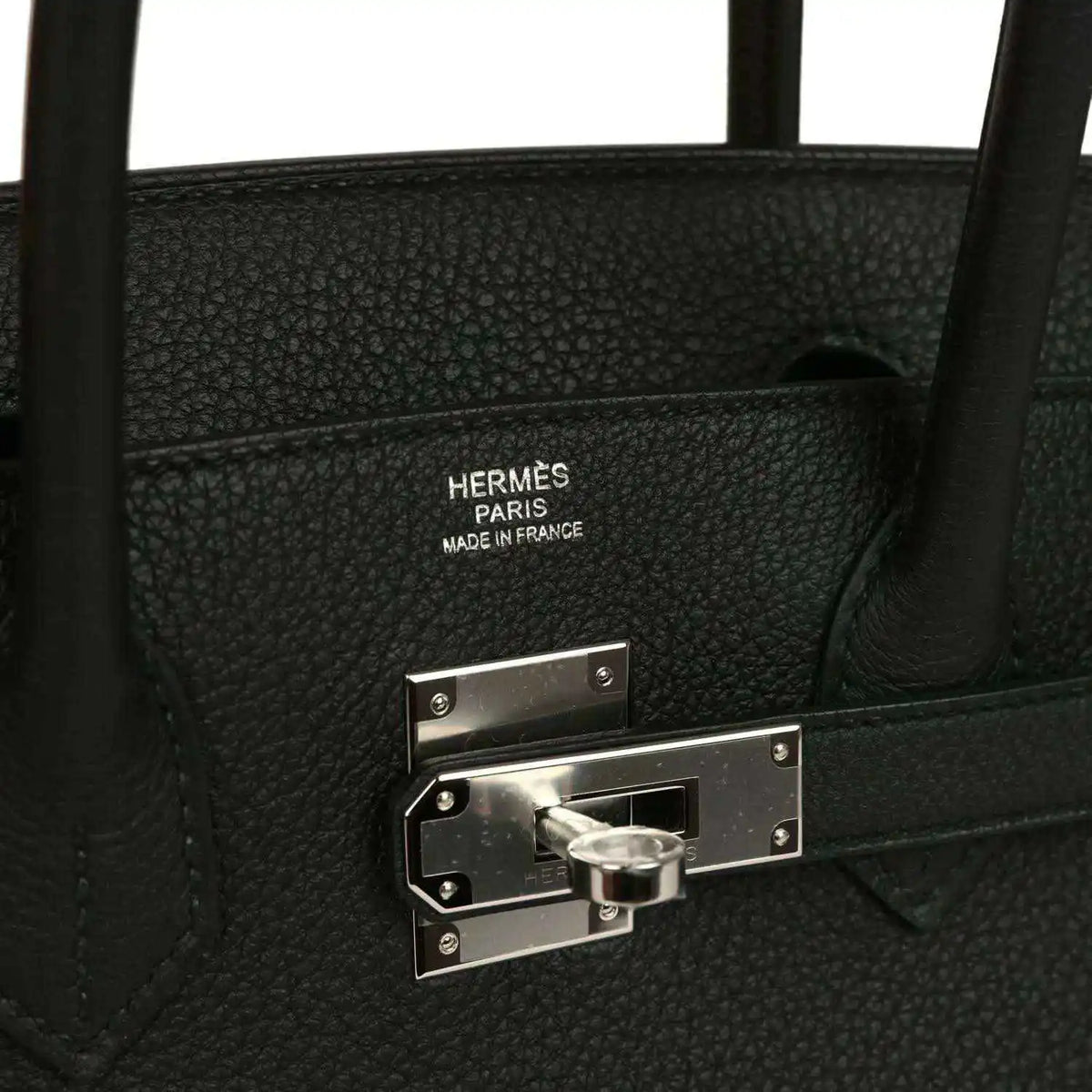 Hermès interior stamp and palladium lock hardware on black leather handbag.