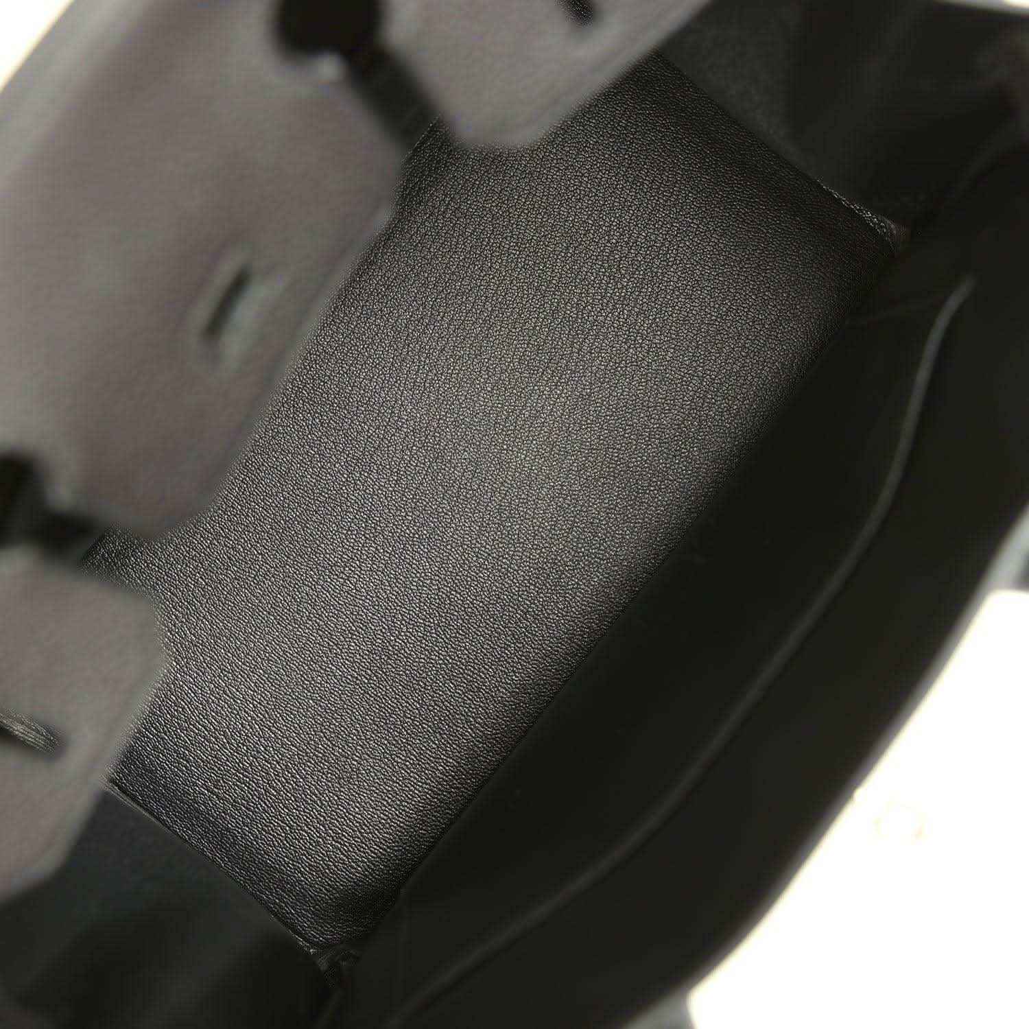 Black leather handbag interior panel with textured grain and stitched edge seams.