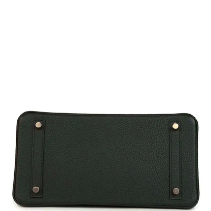 Dark green leather handbag with metal corner details and snap-secured panels