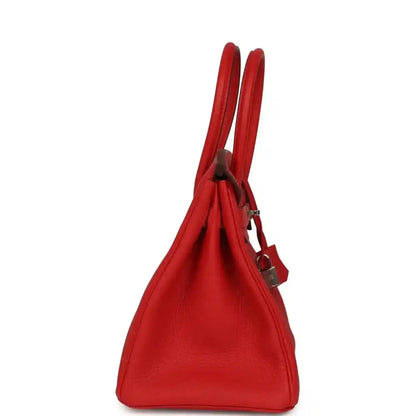 Red Togo leather Birkin 30 bag side view with two top handles and hanging lock strap.