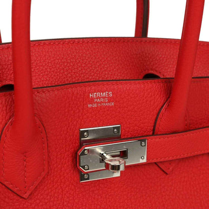 Red Birkin bag interior close-up with Hermes Paris made in France stamp and lock plate.